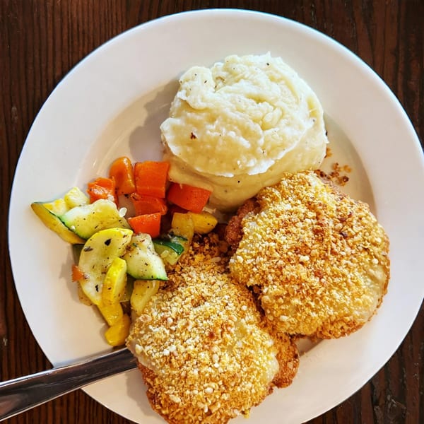 Lucille's American Cafe's crispy fried chicken with mashed potatoes and mixed vegetables.