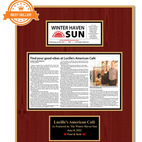 A framed newspaper article from Winter Haven Sun about Lucille's American Cafe, titled "Find your good vibes."