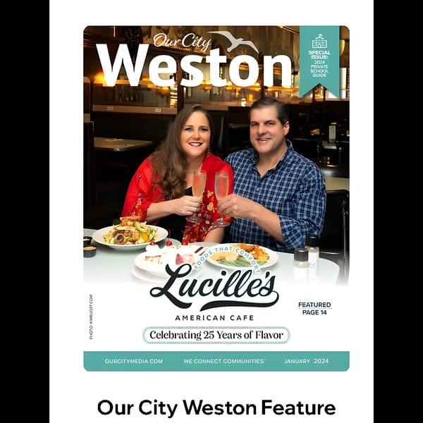 A couple toasting champagne glasses at Lucille's American Cafe, with food and desserts on the table.