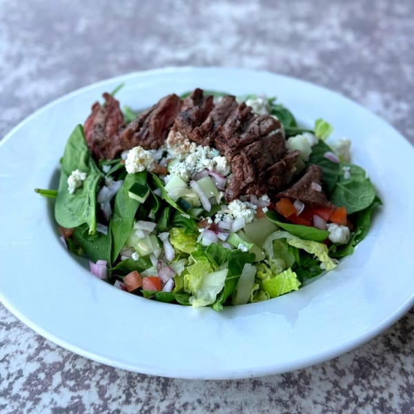 Lucille's American Cafe steak salad with mixed greens, blue cheese, and diced vegetables.